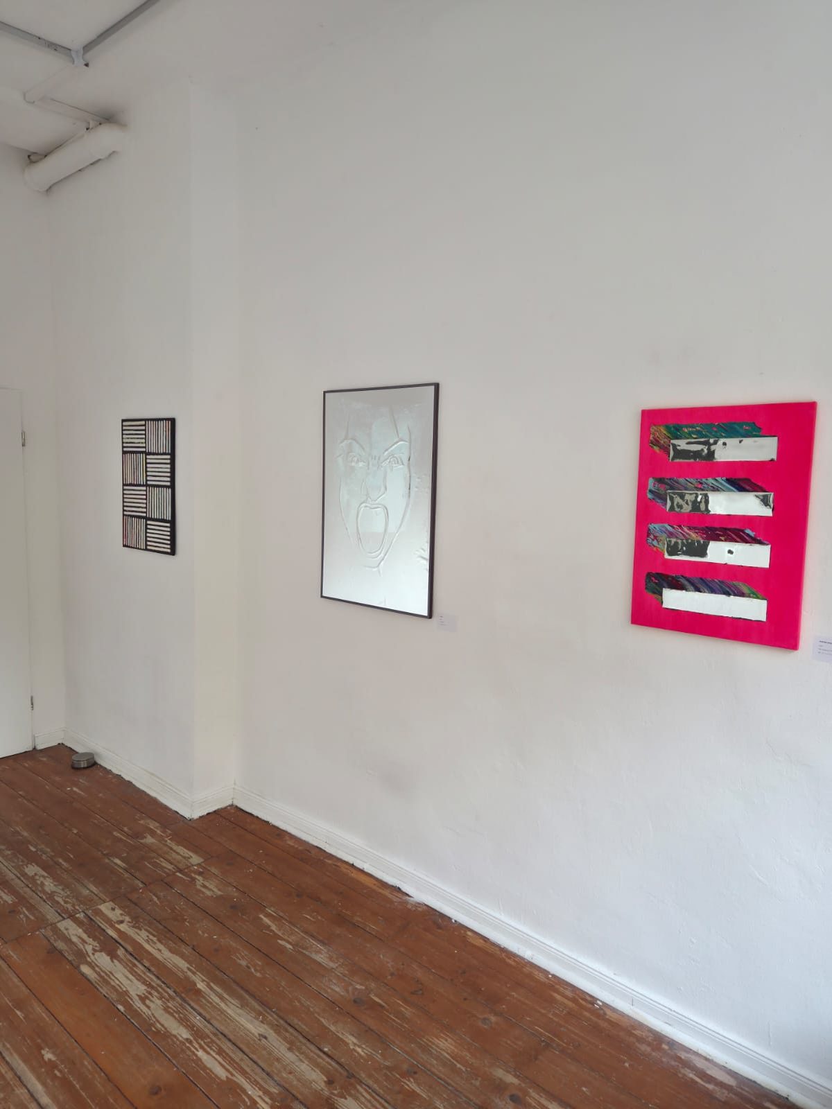 Streifenbild, Relief mit schreiendem Gesicht und pinke Leinwand mit Spiegelstreifen